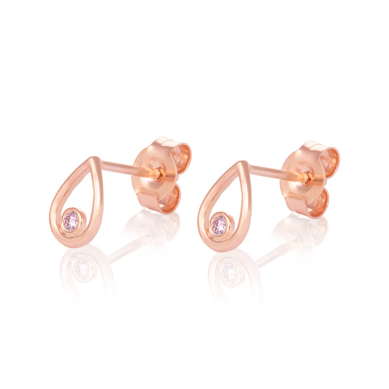 A pair of rose gold teardrop-shaped stud earrings with a small round pink gemstone, shown on a reflective white background.