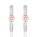 A pair of silver-toned huggie hoop earrings featuring a central round pink gemstone surrounded by a rose gold bezel, with additional clear round-cut stones set along the vertical bars, shown on a white background with a soft reflection.