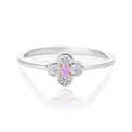 A pink diamond flower ring featuring a central round pink gemstone surrounded by four clear round-cut stones, set on a polished silver band, shown on a white reflective background.