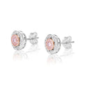 A pair of round stud earrings in silver-tone metal with a central cluster of pink gemstones surrounded by smaller clear stones, shown on a white background with soft reflections.