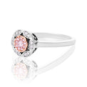 A halo ring featuring a central rose gold cluster of round-cut pink stones surrounded by clear stones, shown on a reflective white background.