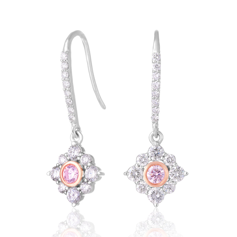 A pair of silver drop earrings with pavé diamond clusters, each featuring a central round pink gemstone, shown on a white background with a soft reflection.