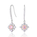 A pair of silver drop earrings with pavé diamond clusters, each featuring a central round pink gemstone, shown on a white background with a soft reflection.